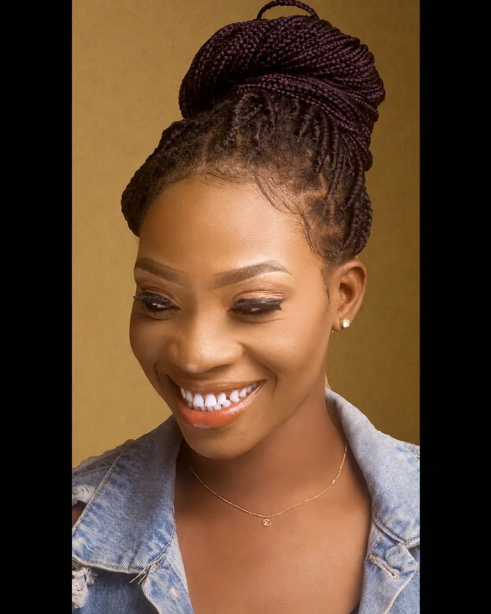 Close-up beauty portrait of a smiling woman with braided hair and denim styling