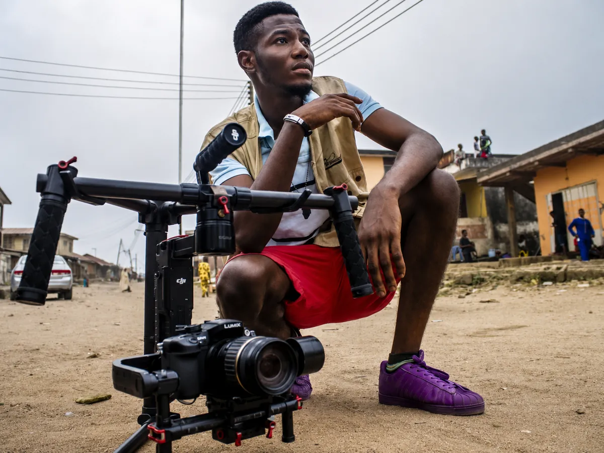 Behind-the-scenes video production moment with Manky Media crew reviewing a camera during a dayttime creative shoot